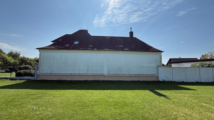 Mauer als Fußballwand, Einschusslöcher im Dach (helle Ziegeln).