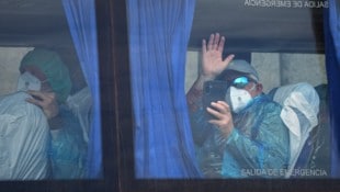 Ein Passagier winkt aus dem Bus nach seiner Evakuierung vom Kreuzfahrtschiff „MV Hondius“ in ...
