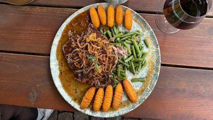 Zwiebelrostbraten mit Kroketten und Speckbohnen.