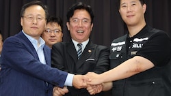 Arbeitsminister Choi Seung-ho (Mitte) zeigte sich über die Einigung zwischen Samsung (links im ...