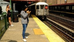 Zwei Frauen warten im teuren Stadtteil Manhattan in New York auf die U-Bahn.