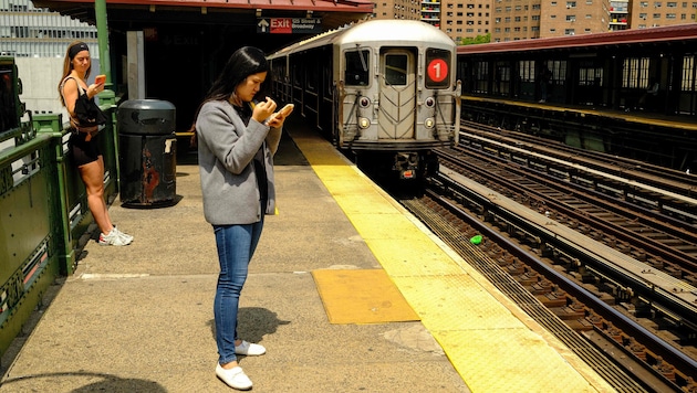 Zwei Frauen warten im teuren Stadtteil Manhattan in New York auf die U-Bahn.
