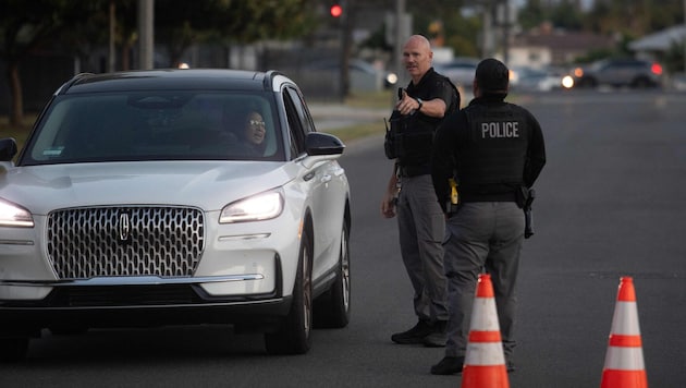 Polizisten leiten Menschen in Garden Grove an, die von der Evakuierung betroffen sind.