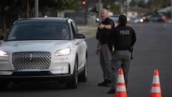 Polizisten leiten Menschen in Garden Grove an, die von der Evakuierung betroffen sind.