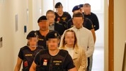 Die Angeklagten im Salzburger Landesgericht, bewacht von Justizwachebeamten.