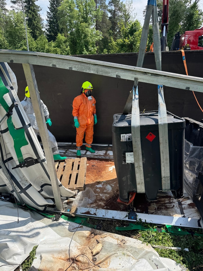 Die Einsatzkräfte mit Anzug und Atemschutzmasken bei den Aufräumarbeiten.