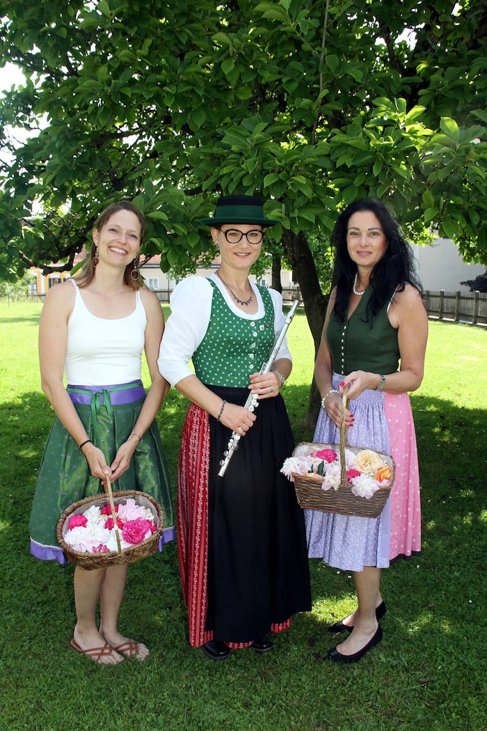 Musikerin Barbara, Jasmin und Veronika (rechts) mit Körben voller Blütenpracht