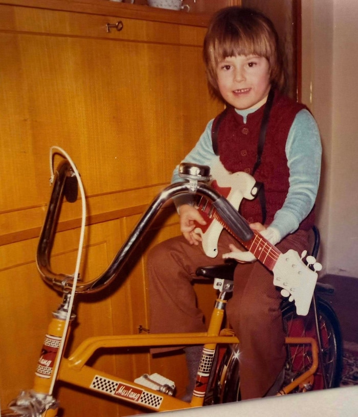 Als kleiner Bub mit Gitarre und Rad.