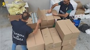 Beamte der Guardia di Finanza beschlagnahmen kistenweise gefälschte Zigaretten.