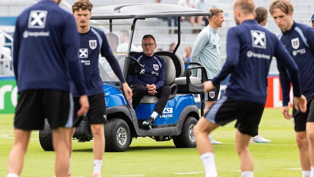 Teamchef Ralf Rangnick (M.) beobachtet das Training vom Golf-Kart aus.