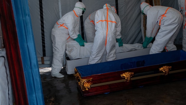 Rot-Kreuz-Mitarbeiter transportieren im Kongo ein Ebola-Todesopfer ab.