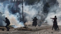Kenianische Polizisten geben auf Motorrädern Schüsse ab, um Demonstranten während eines Protests ...