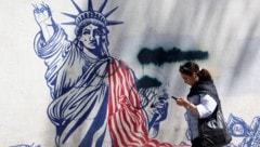 Eine junge Iranerin geht an einem Anti-US-Wandbild in der Nähe einer ehemaligen US-Botschaft in ...