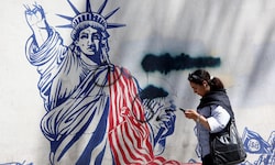 Eine junge Iranerin geht an einem Anti-US-Wandbild in der Nähe einer ehemaligen US-Botschaft in ...