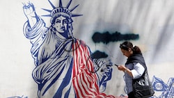 Eine junge Iranerin geht an einem Anti-US-Wandbild in der Nähe einer ehemaligen US-Botschaft in ...