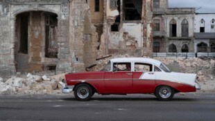 Havanna: Ein altes Auto fährt an den Trümmern eines abgerissenen Hauses vorbei.