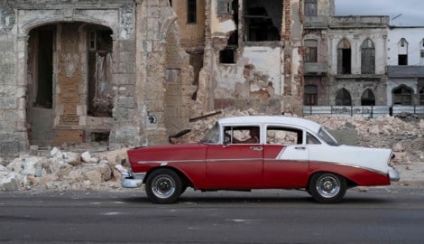 Havanna: Ein altes Auto fährt an den Trümmern eines abgerissenen Hauses vorbei.