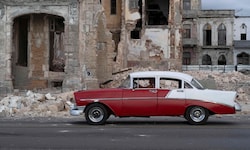 Havanna: Ein altes Auto fährt an den Trümmern eines abgerissenen Hauses vorbei.