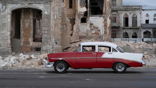 Havanna: Ein altes Auto fährt an den Trümmern eines abgerissenen Hauses vorbei.