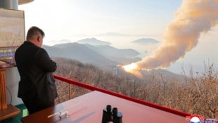 Nordkoreas Machthaber Kim Jong Un beobachtet einen Verbrennungstest eine Raketenmotors.  