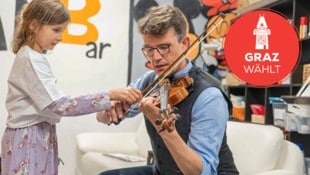 Estelle übt gemeinsam mit dem Chef der Grazer NEOS auf der Geige.  