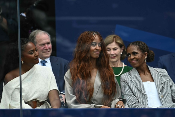 Michelle Obama mit den Töchtern Malia und Sasha, im Hintergrund George W. Bush