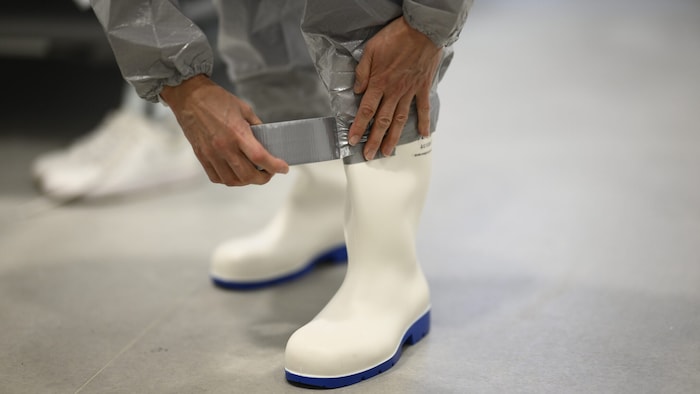 Die Stiefel werden mit dem Schutzanzug verklebt.