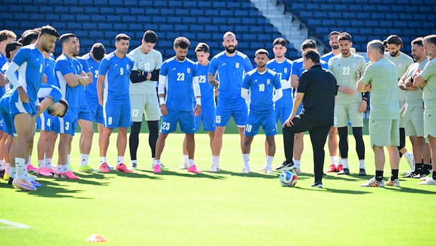 Teamchef Ghalenoei (in Schwarz) stimmt das iranische Team auf das Spiel gegen Ägypten ein.