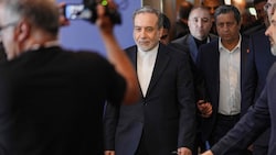 Der iranische Außenminister Abbas Araqchi (m.) ist Teil der Delegation. 