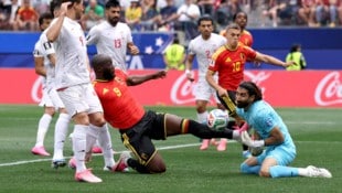 Romelu Lukaku rutscht Irans Keeper Alireza Beirandvand in die Parade. 