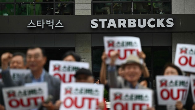 Aktivisten riefen vor Starbucks-Filialen dazu auf, das Unternehmen zu boykottieren.