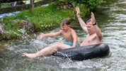 German lässt sich zum Abkühlen im Pinzgau mit seinem Enkerl Johannes durch den Mühlbach in Lofer ...