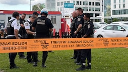 Die Polizei versammelte sich zu einer Besprechung in der Nähe des Tatorts. Zerbrochene Fenster ...