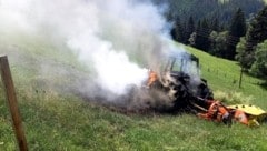 Der brennende Traktor auf der Wiese.