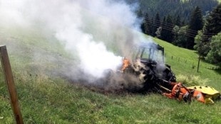 Der brennende Traktor auf der Wiese.