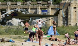 Menschen baden neben russischer Militärausstattung auf der Krim.