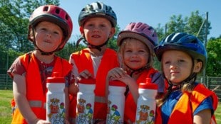 Kleine Radfahrer zeigen ihr Können und werden mit einer Trinkflasche belohnt.  