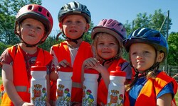 Kleine Radfahrer zeigen ihr Können und werden mit einer Trinkflasche belohnt.  
