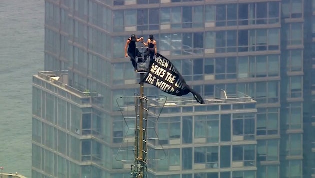 Die beiden Kletterer enthüllten ein Banner mit einer Friedensbotschaft.