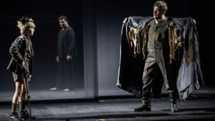 Tamino als Junge und Papageno (Sean Michael Plumb) mit Schwarzmarktware. Im Hintergrund (mi.) ...