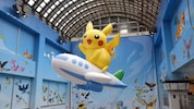 Pikachu begrüßt Reisende in der Lobby des Flughafens.