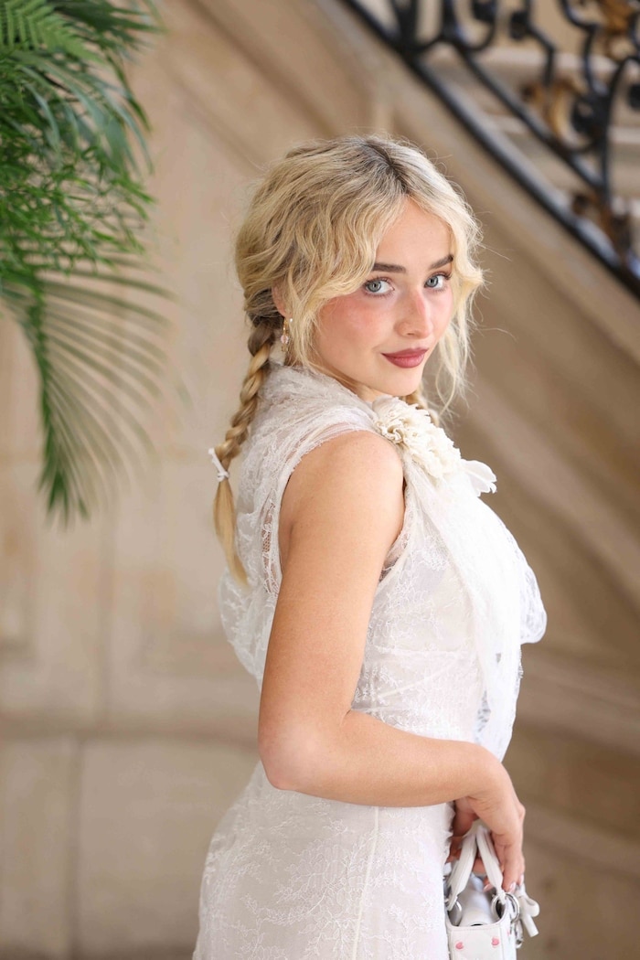 Sabrina Carpenter trug bei der Schau von Dior ein weißes Kleid mit floraler Spitze.
