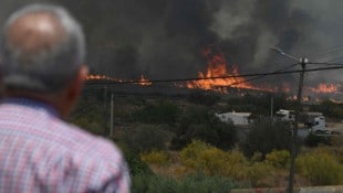 Ein Mann beobachtet, wie die Flammen nahe den Häusern bei Bédar in der spanischen Provinz ...