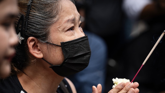 Thailänderin beim Beten für die Brandopfer