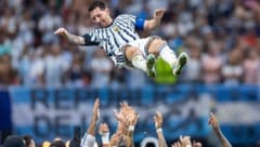 Mitspieler und Fans lassen Argentiniens 10er Lionel Messi hochleben.