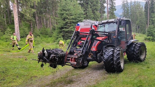 Ein Traktor brachte den verbrannten Motor des abgestürzten Flugzeugs weg .
