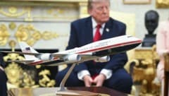 Trump hinter einem Modell der neuen Air Force One – über die neue Präsidentenmaschine will der ...