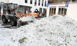 Mitarbeiter der Stadtreinigung entfernen Hagel, der nach einem Unwetter in der Innenstadt von ...