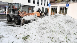 Mitarbeiter der Stadtreinigung entfernen Hagel, der nach einem Unwetter in der Innenstadt von ...