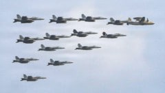 Jets der US-Navy fliegen als Eskorte und Begleitschutz in einer engen Formation mit einem ...